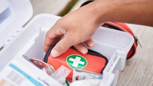 Person reaching into a first aid kit.