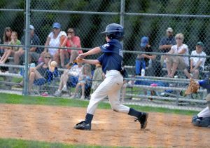 A child plays on a baseball team and hits the ball.