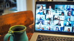 A computer showing multiple video feeds and a blue coffee cup.