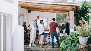 Friends gather for a small event hosted in a backyard with a patio.