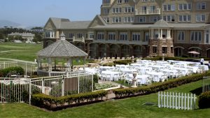 Outdoor wedding venue in front of a mansion with a gazebo.