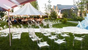 Outdoor wedding venue with white tents and folding chairs.