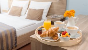 Luxurious hotel room with breakfast tray on the side table.