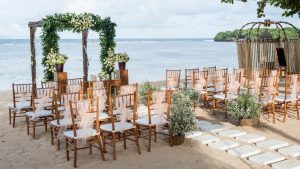 Outdoor wedding venue with white tents and folding chairs.