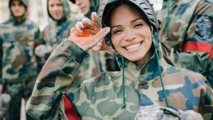 Woman wears Army fatigues during a paintball war.