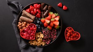 Fruit and chocolates in a decorative bowl.