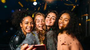 Four women take a selfie at a dance party.