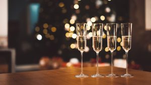 Six employees at a company holiday party holding wine glasses.