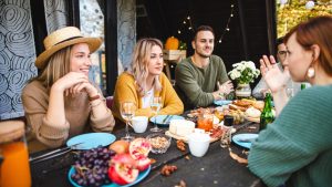 A group of friends enjoy a brunch while sitting at a table in a restaurant's outdoor patio.