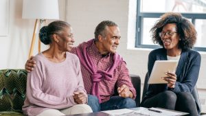 An older couple sits with their event planner reviewing documents.