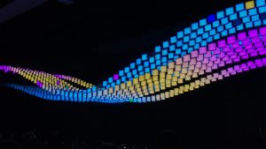 Black background with multi-colored digital image in the shape of a wave.