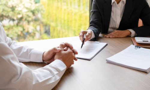 insurance-agent-planning Two men sitting at a conference table filling out an application for event insurance.