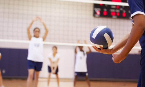 volleyball-team Women in blue and white uniforms playing volleyball.